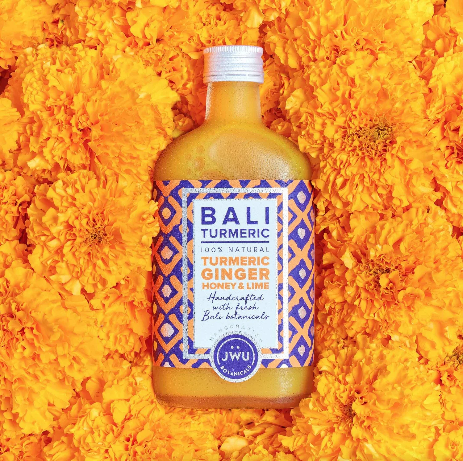 Cold-pressed Bali turmeric tonic on a bed of marigold flowers